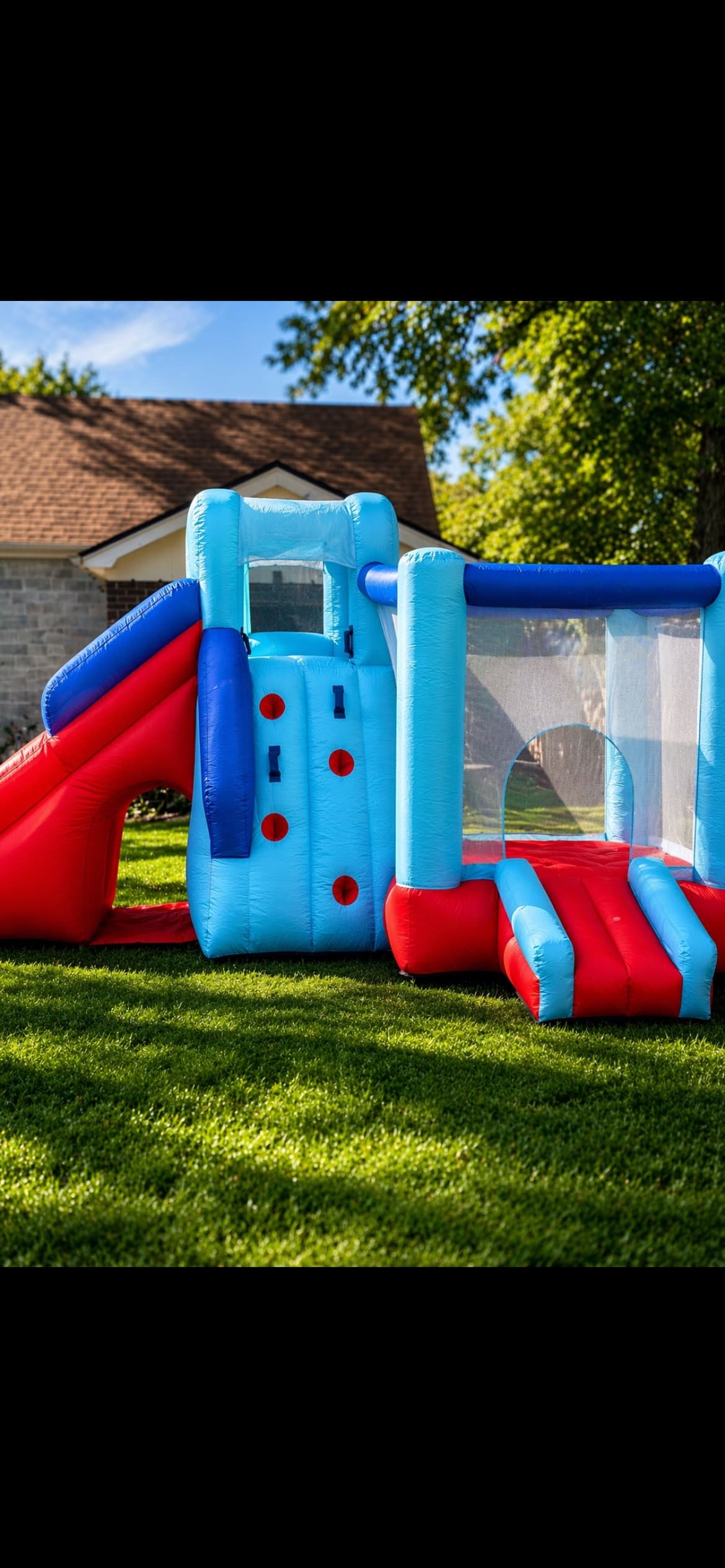 Outdoor bounce house with slide on grass, by Pop & Party Co.